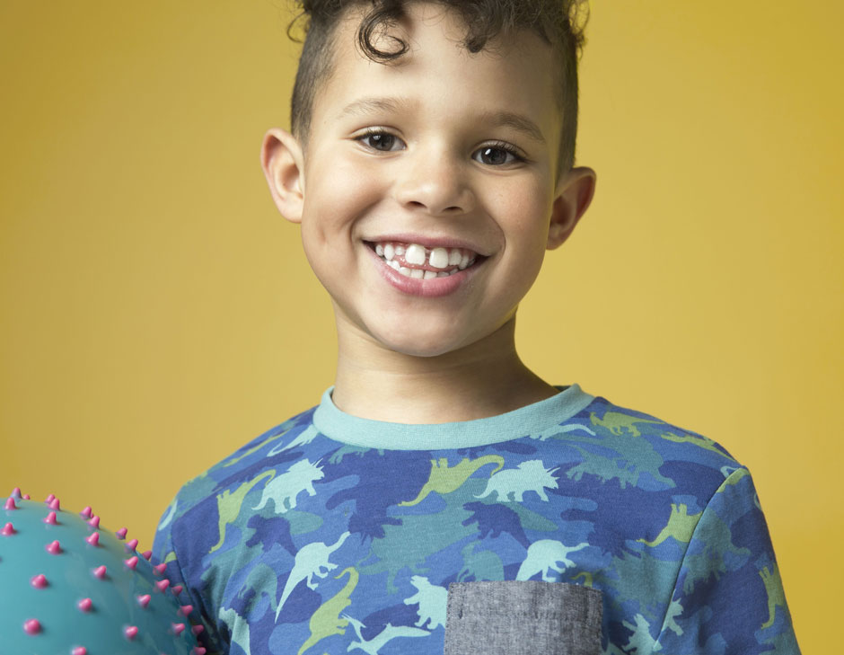 A young child smiling with a gap where a baby tooth has come out